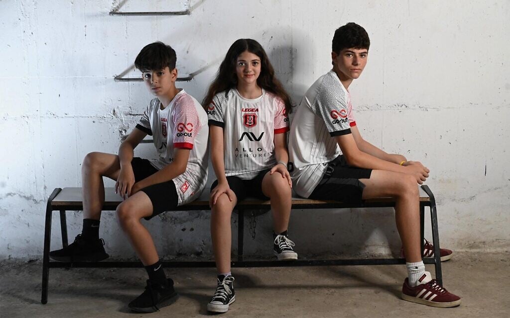 Hapoel fans model new uniforms, with Hersh logo, in bomb shelters