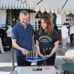 Watch: Noa Tishby lights Hanukkah candles with writer and producer Phil Rosenthal