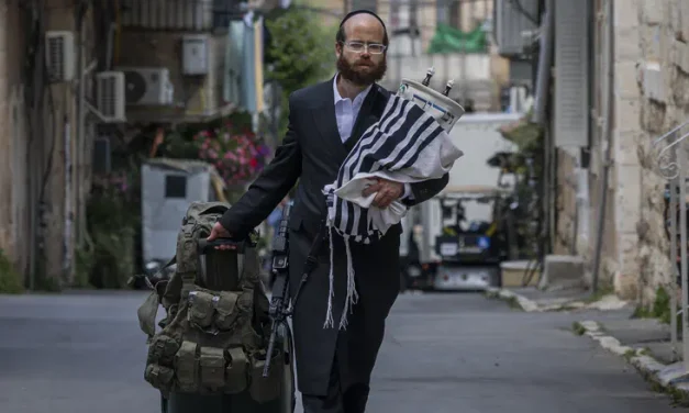 With a gun and Torah scroll: Photo of haredi soldier moves Israel