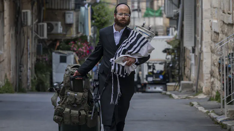 With a gun and Torah scroll: Photo of haredi soldier moves Israel