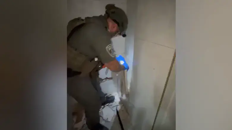 Security forces break wall and find hidden weapon