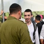 Hundreds of haredim arrive at Tel Hashomer to enlist in IDF as anti-draft protesters gather
